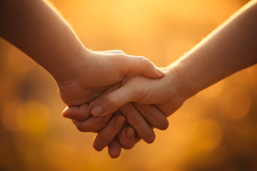 A warmly lit, blurred image of intertwined hands symbolizing rekindled love through a specialist's ritual.
