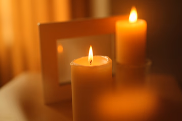 A warmly lit candle beside a framed photo, symbolizing rekindled love and hope for reconciliation.