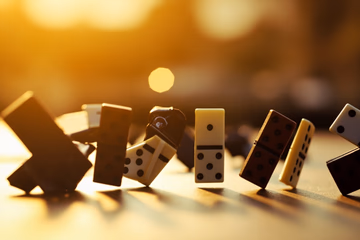 A cascade of dominoes, some upright and some fallen, representing the fleeting nature of purchased TikTok followers.