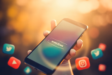 Website address on a phone screen surrounded by social media icons, symbolizing traffic driven by an SMM panel.