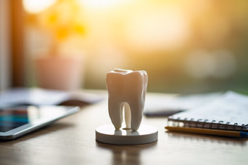A dental model surrounded by marketing tools, symbolizing dental marketing strategies.