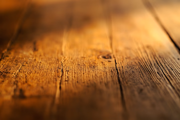Photorealistic image of aged wood grain texture with a blurred background.