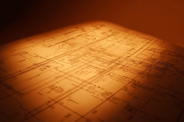 Blueprint representing a business plan, symbolizing strategic planning and expert guidance.