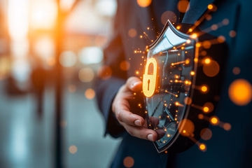 A shield icon representing fraud prevention over a blurred background of online transactions.